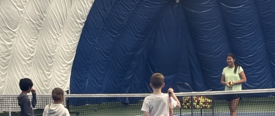 Emery coaching young beginner tennis students at Castle Rock Tennis indoor bubble court